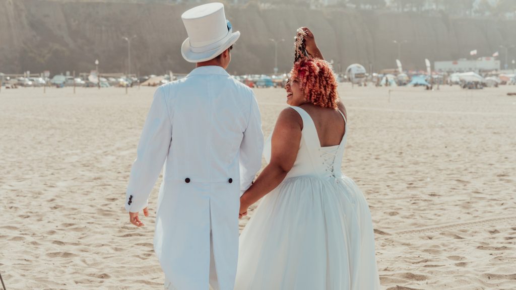 Bride and groom walking together on the beach