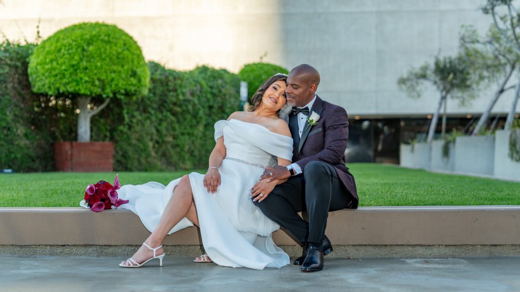 Bride and groom seated together in a modern courtyard