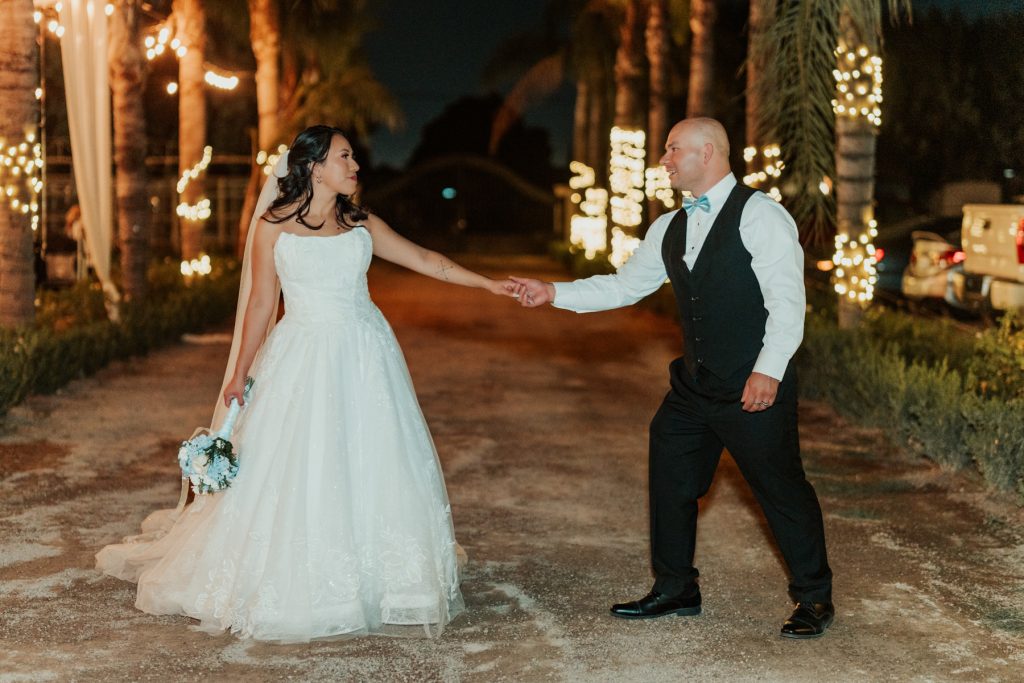 Couple holding hands under string lights at night